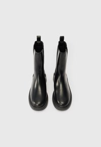 Crne kožne čizme do gležnja s glatkom površinom, zaobljenim vrhom, elastičnim bočnim panelima i držačem na peti. Gumeni đon s detaljima šivanja.