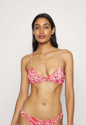 Bikini em padrões rosa e vermelho com um centro atado, tiras finas trançadas e detalhes em metal nas cuecas. Textura de tecido suave.