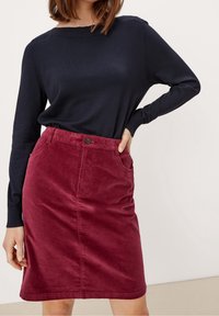 Granatowy sweter z długim rękawem w połączeniu z bordową spódnicą z kordurowego materiału z zapięciem na guziki z przodu i kieszeniami po bokach. Miękka struktura i prosty design.