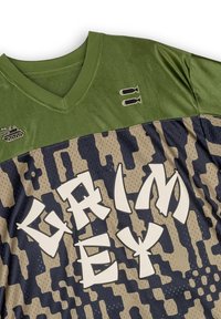 Jersey verde y azul marino con cuello en V, que presenta un patrón de camuflaje y un audaz texto blanco "GRIMEY". Incluye gráficos de tanque y bomba.