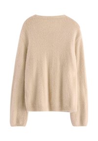 Beige pehmeä villapaita pitkilla hihoilla, pyöreällä kaula-aukolla ja pehmeästä, teksturoidusta kankaasta. Takana on saumaton muotoilu ja hieman rento istuvuus.