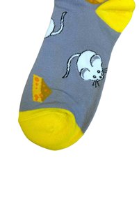 Graue Socke mit gelber Zehen- und Fersenpartie, die ein Muster aus weißen Mäusen und keilförmigen, orangen Käseillustrationen zeigt.