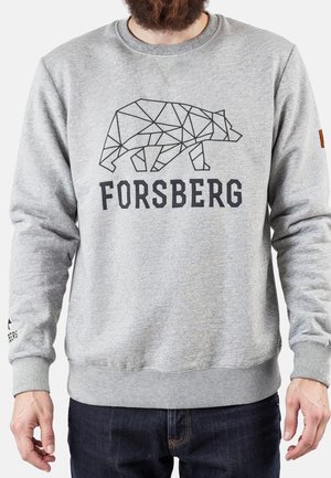 Grå sweatshirt med geometrisk bjørnemotiv og teksten "FORSBERG", båret af en person med skæg og mørke bukser.