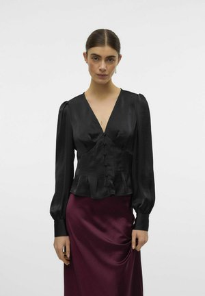 Black satin blouse with long puff sleeves, a deep V-neck, and a button front. Worn with a burgundy satin skirt featuring a draped detail.