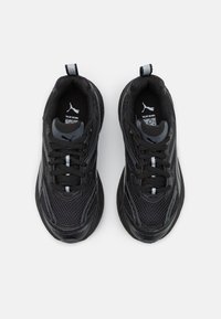 Black athletic shoes with mesh upper, textured panels, and reflective accents. Features traditional lacing and a pull tab on the tongue.