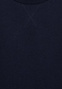 Laiviniai mėlyni ilgomis rankovėmis marškiniai su šonkačių tekstūra, apvaliu iškirpimu ir X raštu, siuvinėtų atitinkančios spalvos siūlais ant apykaklės, papildomam akcentui.