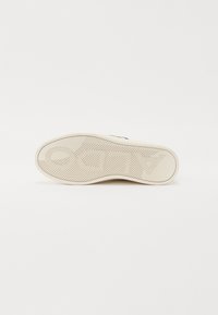 Beebikummist sneakersi talla, millel on kalakeelne mustrikujundus ja pressitud logo. Sile tekstuur ja ümar kand.