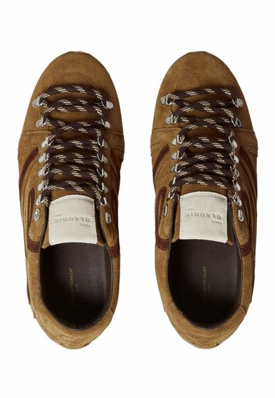 Scarpe in pelle scamosciata marrone con lacci marroni scuri e accessori in argento. Presentano un motivo testurizzato sulla parte superiore e un morbido rivestimento interno scuro.