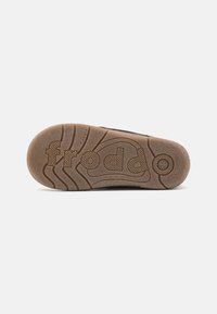 La semelle en caoutchouc brun présente un motif texturé avec le nom de la marque "froddo" en relief. Conception absorbant les chocs avec des détails de traction.