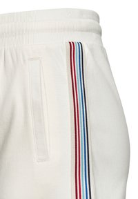 Weiße Jogginghosen mit einem gerippten Bund, seitlichen Taschen und einem gestreiften Design in Rot, Blau und Grau entlang der äußeren Naht.