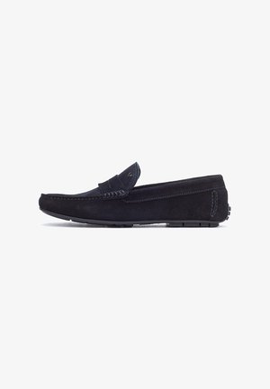 Mocassins en daim marine avec un embout moccasin cousu, un accent en cuir sur le cou-de-pied et une semelle en caoutchouc avec un grip texturé.