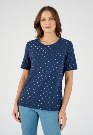 Camiseta azul marino de manga corta, con cuello redondo y estampado de lunares blancos en toda la prenda. Fabricada en tejido suave y transpirable.