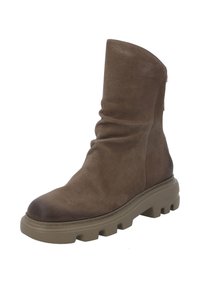 Bota de tobillo de cuero marrón con un upper texturizado, diseño caído y suela de goma gruesa con surcos profundos.