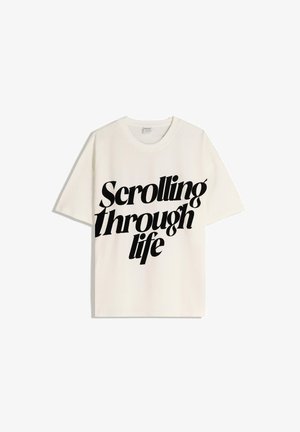 Tricou alb din bumbac cu mâneci scurte, care prezintă un text îndrăzneț în negru, citind "Deruland prin viață" în fonturi și dimensiuni variate.