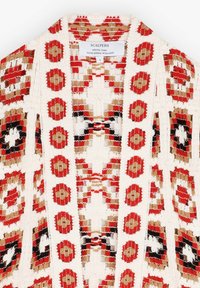 Witte geweven kimono met rode, zwarte en gouden geometrische patronen. Heeft een open voorkant en gemiddelde textuur, gelabeld "SCALPERS."