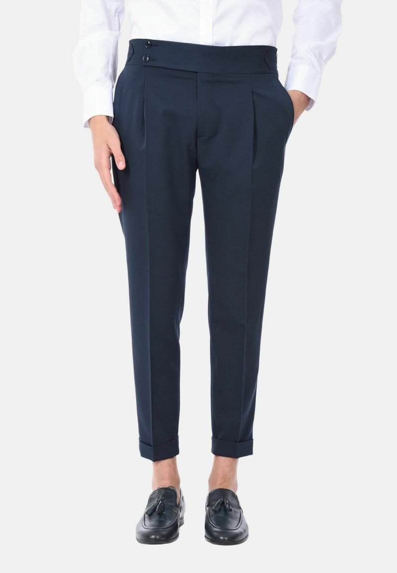 Pantaloni tailored blu navy con pieghe, chiusura con due bottoni in vita e risvolti, realizzati in un tessuto morbido.