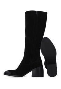 Zwarte laarzen van suède tot halverwege de kuit met een zijrits en een blokhak, één laars rechtopstaand en de andere met de zool zichtbaar.