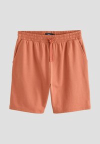 Shorts de color melocotón hechos de una tela suave, con cinturilla elástica, cordón y bolsillos laterales.