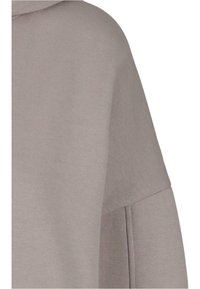 Világosszürke, oversized kapucnis pulóver, amelynek puha felülete van, széles nyaknyílással és ejtett vállvarrással rendelkezik. Minimalista varrási részletekkel rendelkezik.
