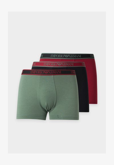 Τρία ζευγάρια ανδρικά boxer Emporio Armani σε πράσινο, μαύρο και κόκκινο με λωρίδες μέσης με λογότυπο, στοιβαγμένα σε λευκό φόντο.