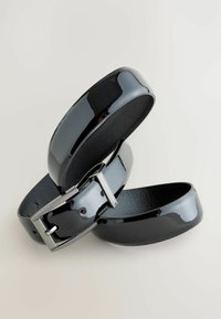 Schwarzer Lackledergürtel mit glänzender Oberfläche, ausgestattet mit einer silberfarbenen Metallschnalle und strukturierten Akzenten auf der Schnalle.