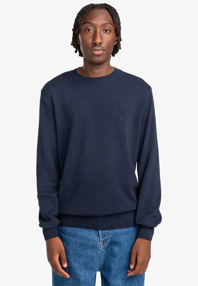 Navyblauer Pullover aus weichem Stoff, mit Rundhalsausschnitt, langen Ärmeln, gerippten Bündchen und einem dezenten Logo auf der Brust.