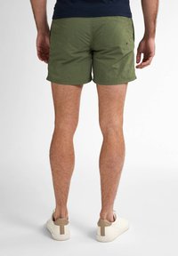 Pantaloni corti verde oliva con una texture leggera, caratterizzati da un design semplice e un piccolo dettaglio del logo sul retro.