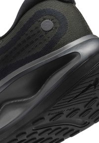 Chaussure vert foncé avec tige en tissu texturé, talon arrondi et semelle en caoutchouc noire présentant un motif de bande de roulement et un détail de marque.