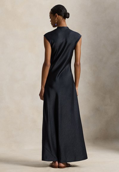 Μαύρο, αμάνικο μάξι φόρεμα με ψηλό γιακά και λεία υφή, με ελαφρώς Α-γραμμή και άνοιγμα στη φτέρνα πίσω.