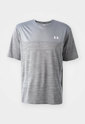 Camiseta deportiva gris hecha de tela transpirable. Presenta un panel superior liso, un cuerpo inferior texturizado y el logo de Under Armour en el pecho.