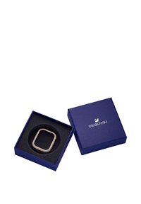 Open donkerblauw Swarovski-doosje met een vierkant versierd kader met kristallen binnenin, op een witte achtergrond.