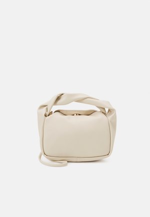 Petit sac à main beige doux avec une bandoulière torsadée et une forme rectangulaire arrondie sur un fond uni.