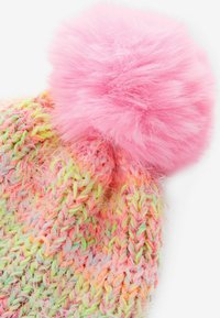Gehaakte beanie van meerkleurig pastelgaren met een grote, pluizige roze pompon bovenop. De textuur lijkt zacht en fuzzy.