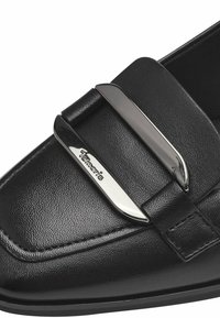 Mocassin en cuir noir avec une surface texturée, mettant en avant un accent métallique argenté et un détail de logo sur le côté. Design à bout rond et lisse.