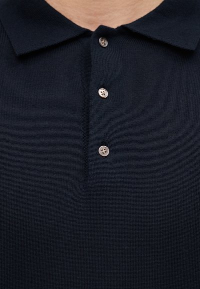 Tumesinine kudumispolo särk, millel on kokkupandav krae ja esiküljel kolm nähtavat nuppu.