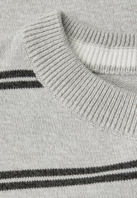 Grå stickad tröja med ribbad hals och två svarta ränder över bröstet. Texturen är mjuk med en fin, slät yta.