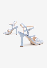 Sandali con tacco alto blu chiaro, dotati di molte cinghie incrociate, chiusura con fibbia e finitura lucida su un tacco a stiletto curvo.
