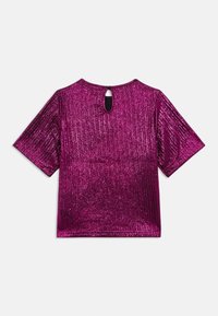 Top magenta a maniche corte con superficie testurizzata e lucida, caratterizzato da un'apertura a chiave sul retro con chiusura a bottone.