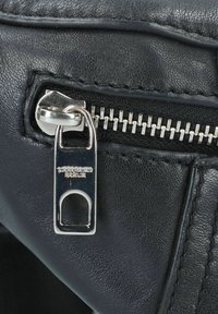Schwarzes Leder mit Reißverschlussdetails und silberner Hardware. Verfügt über eine genähte Kante und ein Logo-Tag, das auf dem Reißverschlusszuggriff eingeprägt ist.