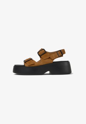 Sandales à plateforme en suede marron avec semelles en caoutchouc noir, dotées de deux sangles réglables avec boucles noires et d'un design à dos ouvert.