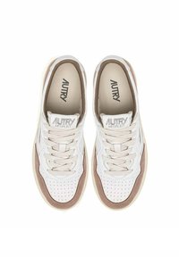 Sneakers bianche con accenti beige, dotate di un upper testurizzato, punta rotonda e chiusura con lacci. Logo visibile sulla linguetta.