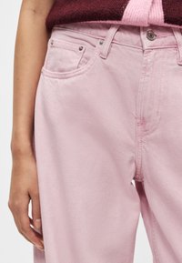 Rozā džinsa bikses ar taisnu kāju dizainu, ar priekšējiem kabatām, sudraba aparatūru un smalku teksturētu apdari.