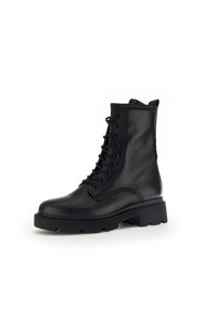 Černé kožené šněrovací kotníkové boty s kulatou špičkou, silnou gumovou podrážkou a detailním prošíváním po stranách.