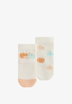 To hvide ankelstrømper med orange tåspidser og flerfarvede smilende græskar mønstre i orange, beige og lyseblå.