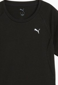 Camiseta negra de mezcla de algodón, con cuello redondo, mangas cortas y un logo blanco de Puma en el lado izquierdo del pecho. Textura suave.