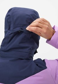 Navy- und lila wasserdichte Jacke mit Kapuze und Zugbandanpassung, die strukturierter Stoff und Nahtdetails im Rücken- und Schulterbereich zeigt.