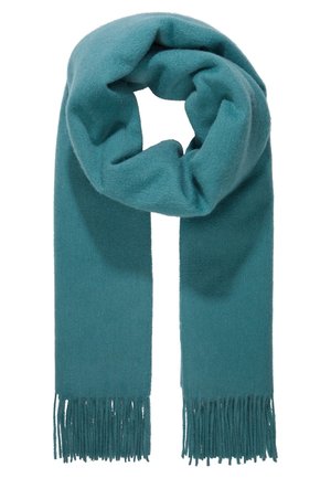 Zachte turquoise wollen sjaal met franjes aan de uiteinden, gevouwen in een lus tegen een witte achtergrond.