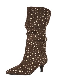 Botín de ante marrón hasta el tobillo con punta afilada, diseño plisado y adornos de tachuelas doradas por toda la superficie. Presenta un tacón kitten para mayor elevación.