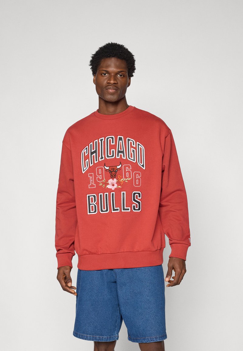 Sweatshirt rouge avec des graphiques "CHICAGO BULLS 1966", comportant un taureau et un motif floral. Accompagné d'un short en denim ; coupe décontractée.