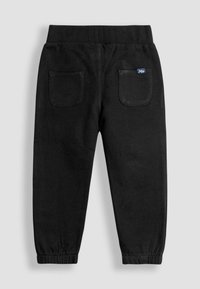 Pantalones de chándal negros con una cinturilla acanalada, que cuentan con dos bolsillos traseros y puños elásticos, confeccionados en una tela suave y lisa.